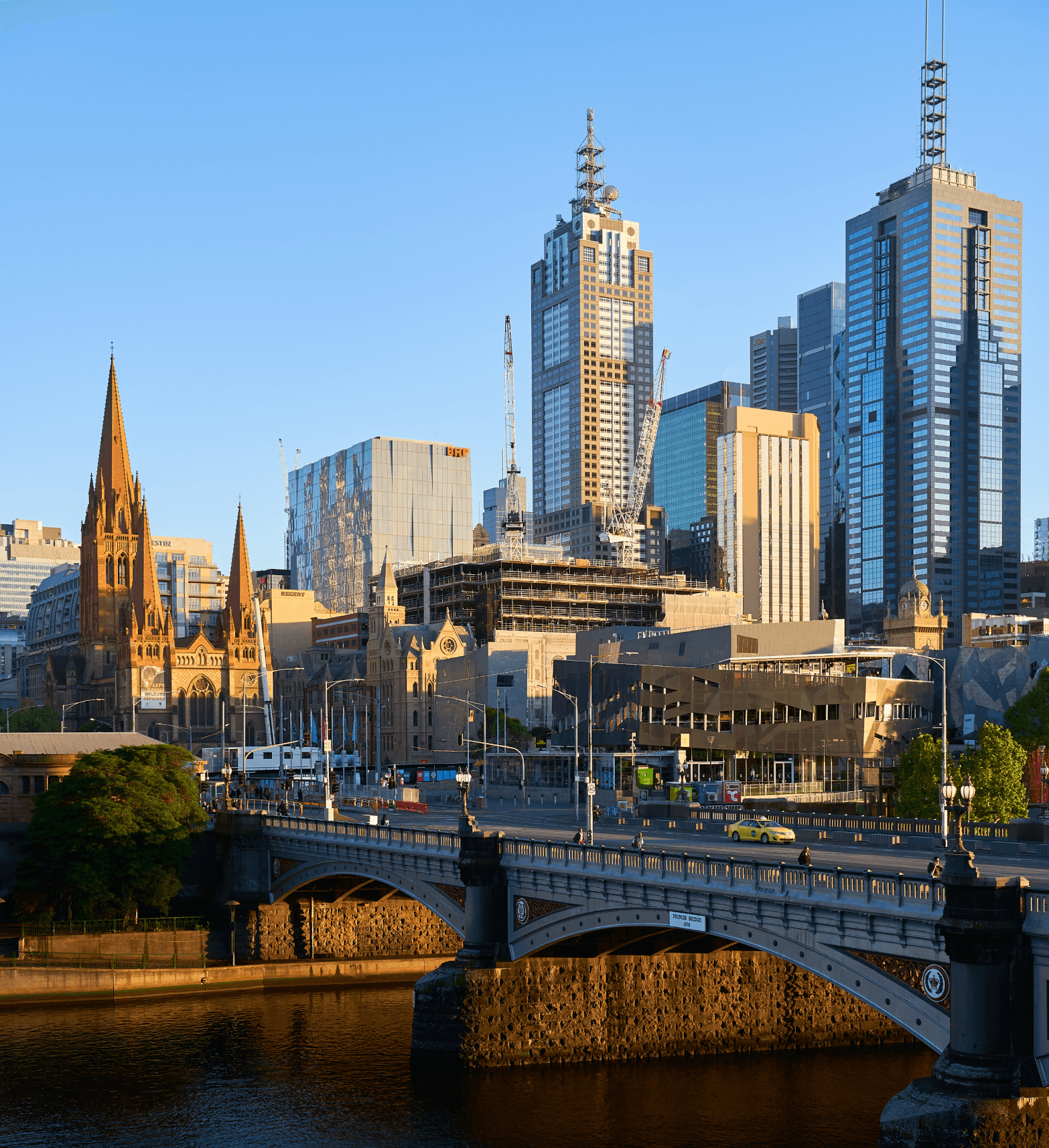 An image of Melbourne from the Yarra River looking over the city, Flinders Street station, St Paul's Cathedral and Fed Square